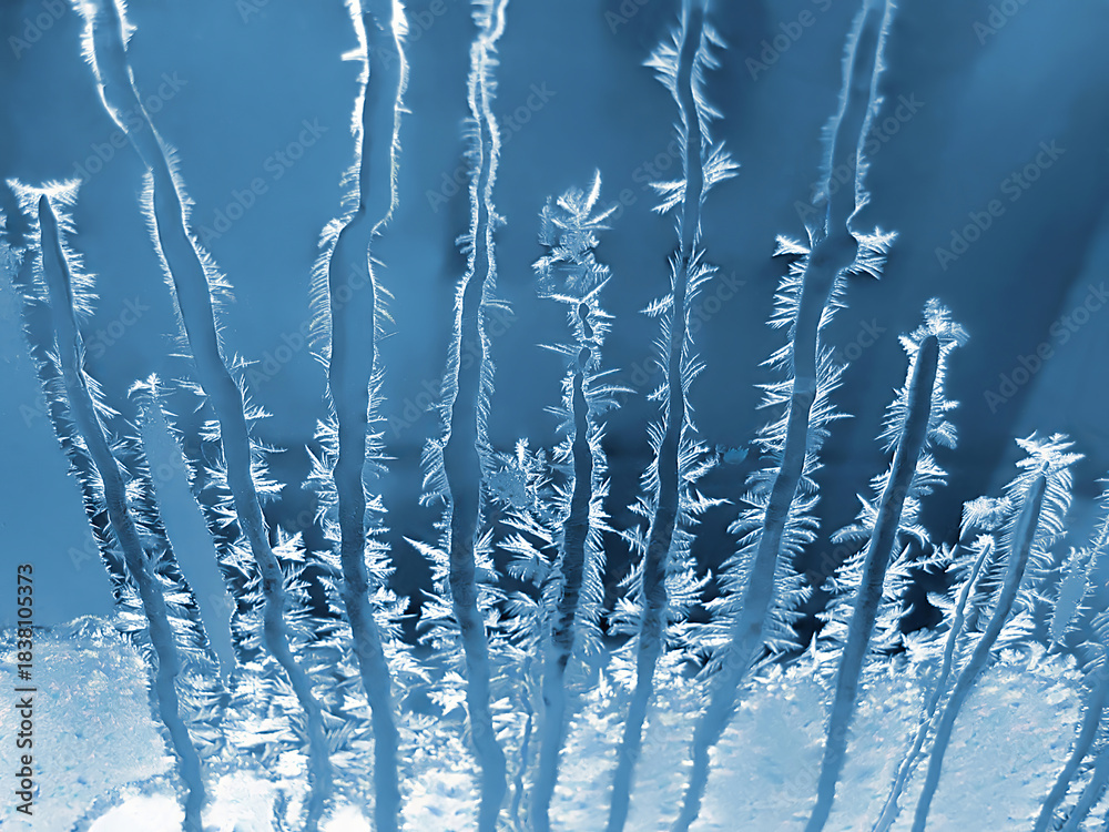 Fototapeta premium Beautiful ice pattern on window glass, close-up natural winter background