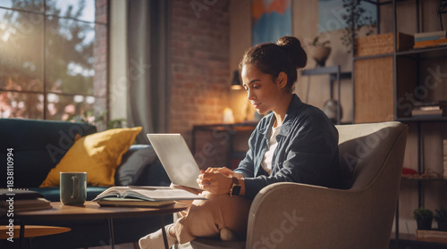 Woman working on laptop sitting in comfortable armchair