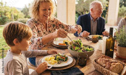 Grandparents with family at table outdoor for celebration during lunch