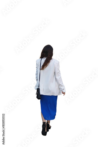 Rear view of a woman with long hair in a dress and jacket carrying a black women's bag walks forward isolated on white background