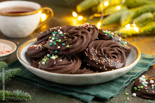 Christmas chocolate sable cookies decorated with chocolate and sprinkles. New Year's festive dessert. Selective focus