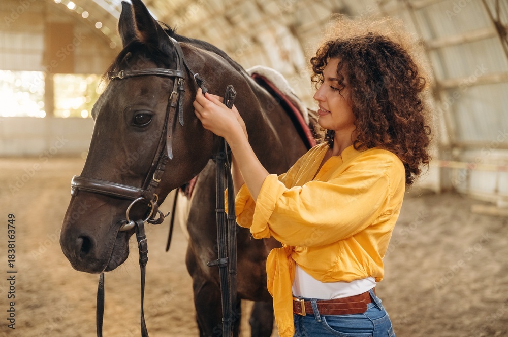 Obraz premium Taking care of animal. Beautiful young woman is with horse in hangar