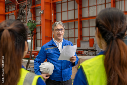 Supervisor of diverse engineers briefing his team before working in manufacturing factory. Leader giving a briefing to team in industrial site. Worker manager conducting a site meeting in a factory.