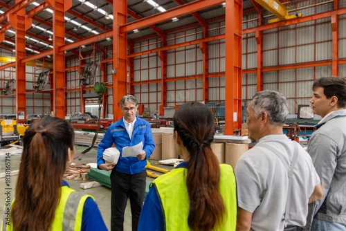 Tablou pe pânză Supervisor of diverse engineers briefing his team before working in manufacturing factory