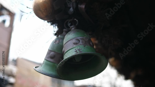 Close-up of rustic green metal bells hanging outdoors. Decorative vintage bells suitable for holiday or winter market themes