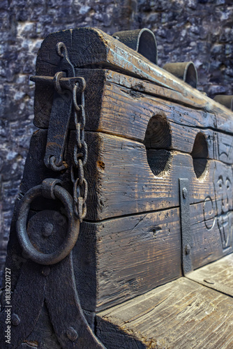 Rusty old logs, close-up view, historical torture device for physical punishment with iron handcuffs and a hole for the feet.