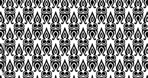 Black and white ethnic-style pattern with repeating flame-like and teardrop shapes arranged symmetrically.