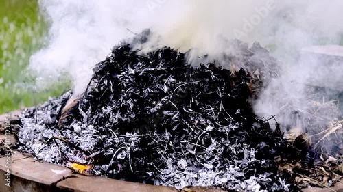 dangerously hot orange and red flames with dense black smoke consuming wood and embers