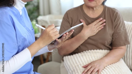 Wallpaper Mural Caregiver in uniform explaining healthcare information to senior patient using digital tablet, focusing on understanding, communication, trust during home consultation, wellbeing awareness, recovery Torontodigital.ca