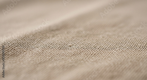 Neutral-toned textile fabric with visible weave pattern and subtle texture, presenting a close-up