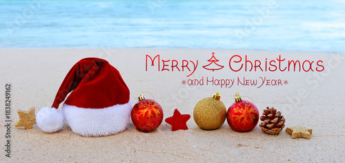 Merry Christmas background with red Santa Claus Hat on Caribbean beach.
