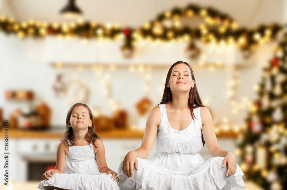 Naklejka premium Healthy mother and girl doing yoga at christmas morning