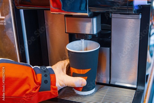 A man pours coffee from a coffee machine at a gas station