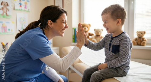 A woman nurse engages in play with a smiling boy in a hospital room