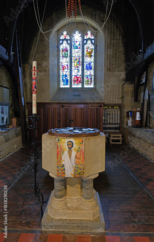 Tableau sur toile Historic Stone Baptismal Font and Colorful Victorian Stained Glass in Rogate Chu
