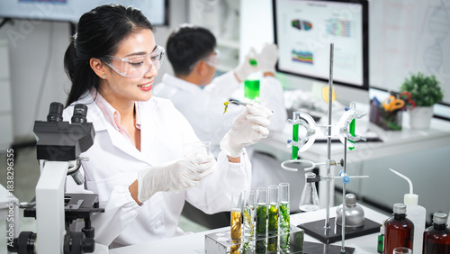 Scientist working in a biology lab examining algae extract for biotechnology and cosmetic research. Test tubes, green samples, and lab equipment highlight natural formulation and scientific innovation