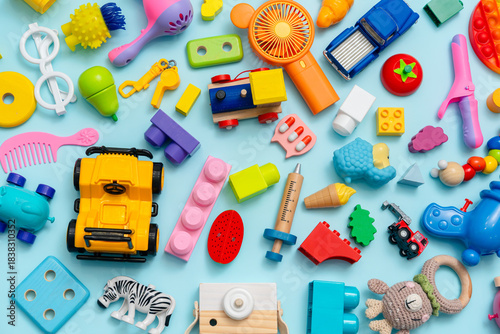 Lots of different children's toys on a blue background with space for text, top view, flat lay