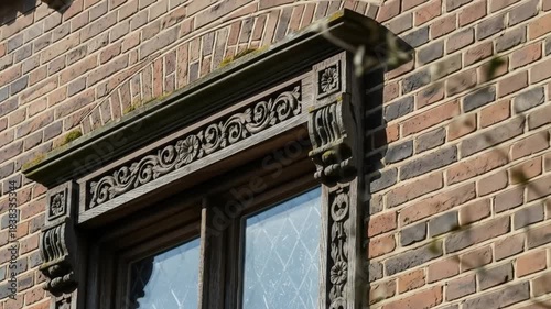 Closeup of Ornate Carved Window Frame on Brick Building with Frosted Glass in Natural Daylight