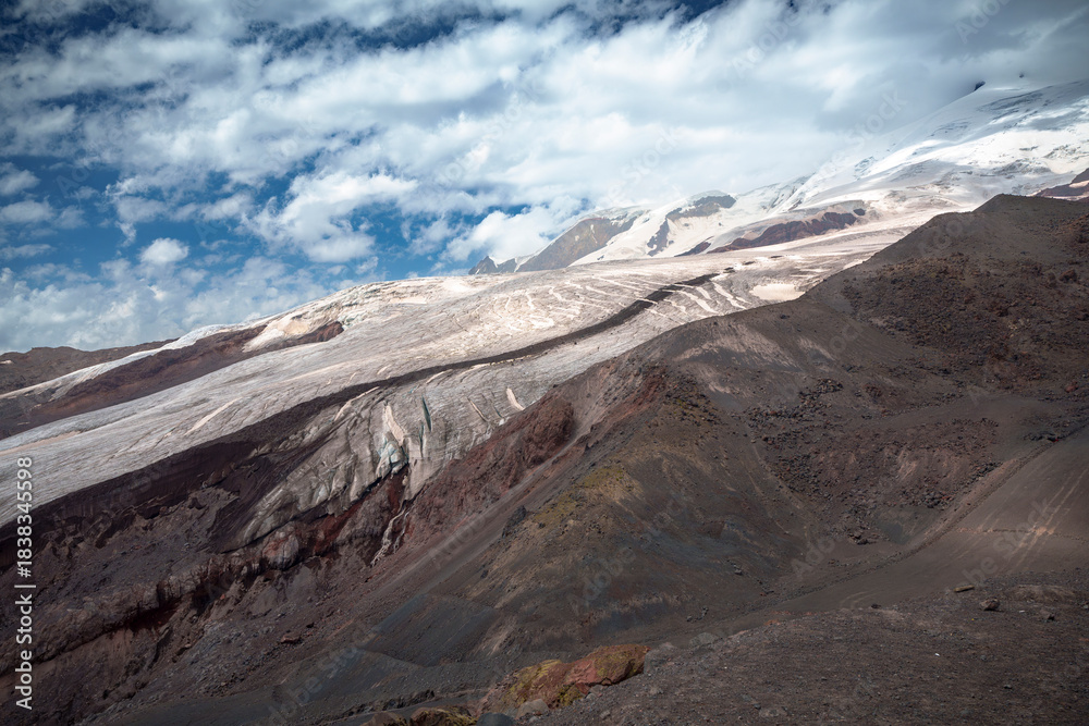 Naklejka premium Mountain landscape with glacier and snow-covered peaks under blue sky