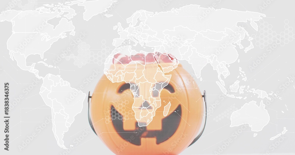 Fototapeta premium Displaying plastic orange jack-o'-lantern bucket center-front in studio, with world map overlay