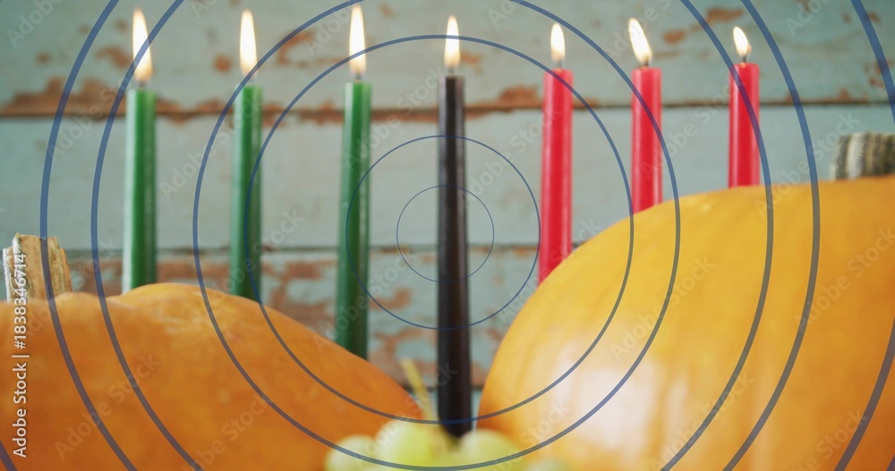 Naklejka premium Displaying kinara candleholder with 7 lit tapers burning on table, pumpkins, apple, wall overlay