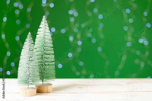 Small christmas trees on table against bokeh background