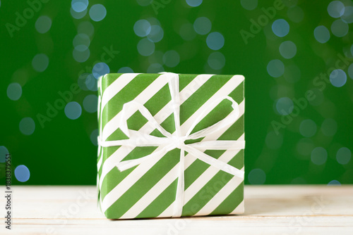 Christmas gift box on table against bokeh background