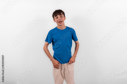 young casual dressed white male Gen Z model teenage boy with braces,  happy smile expressing relaxed confidence in positive happy way. plain background studio setting blue t-shirt