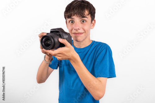 young photographer casual dressed Generation Z white male model fun teenage boy photo with DSLR camera. happy smile expressing joy in positive entertaining way in plain background studio setting