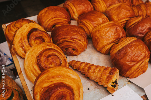 Fresh cinnamon and chocolate rolls on baking paper. Assortment of fresh pastries on the counter