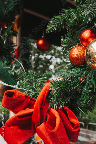 Large red bow on a Christmas wreath close up. Bright decorations for the New Year