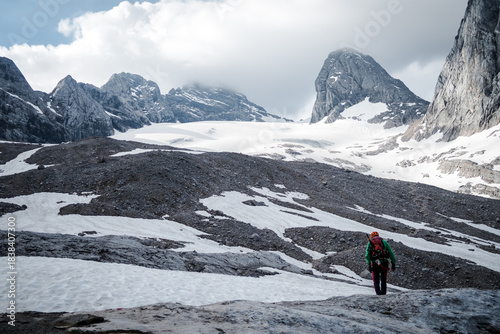 Solo Alpinist Crossing Rocky Glacier below Dachstein Terrain in Austrian Alps