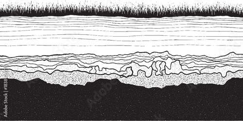 Cross section of soil layers with grass on top and dark earth below.