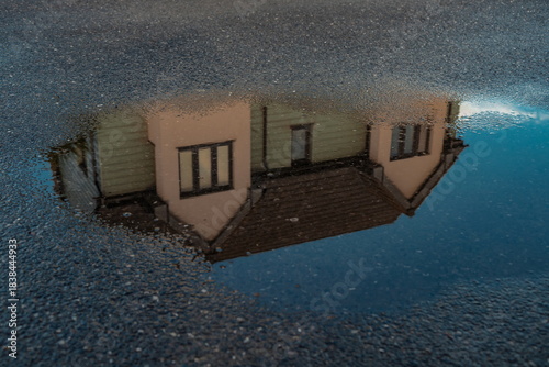 House reflected on the surface of the water on the street