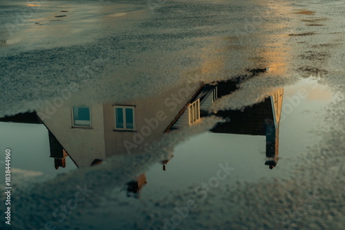 House reflected on the surface of the water on the street