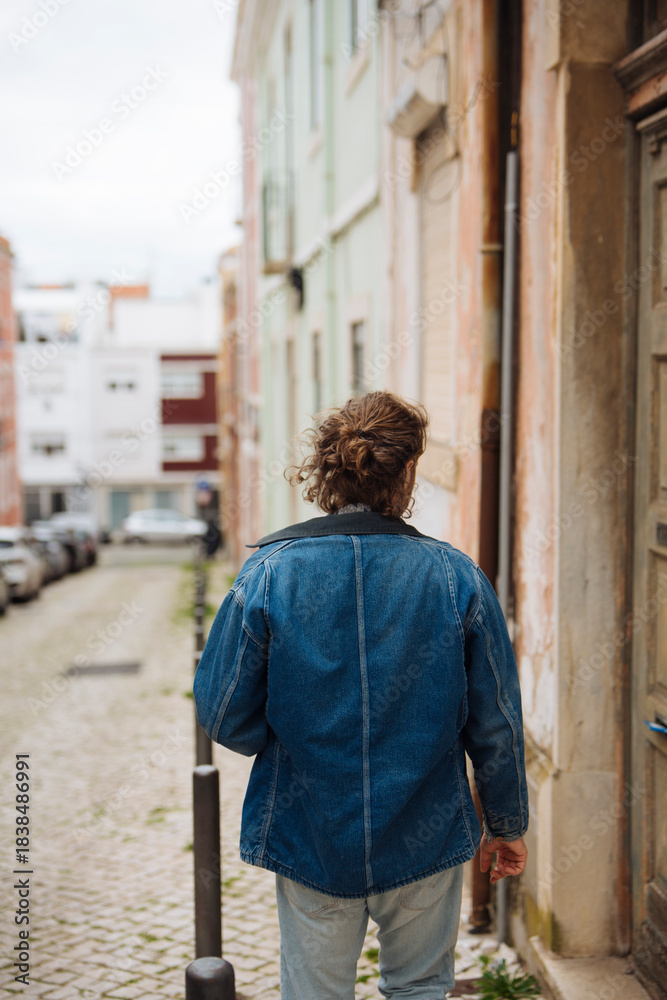 Fototapeta premium Someone wearing jacket wanders through historic cobbled streets
