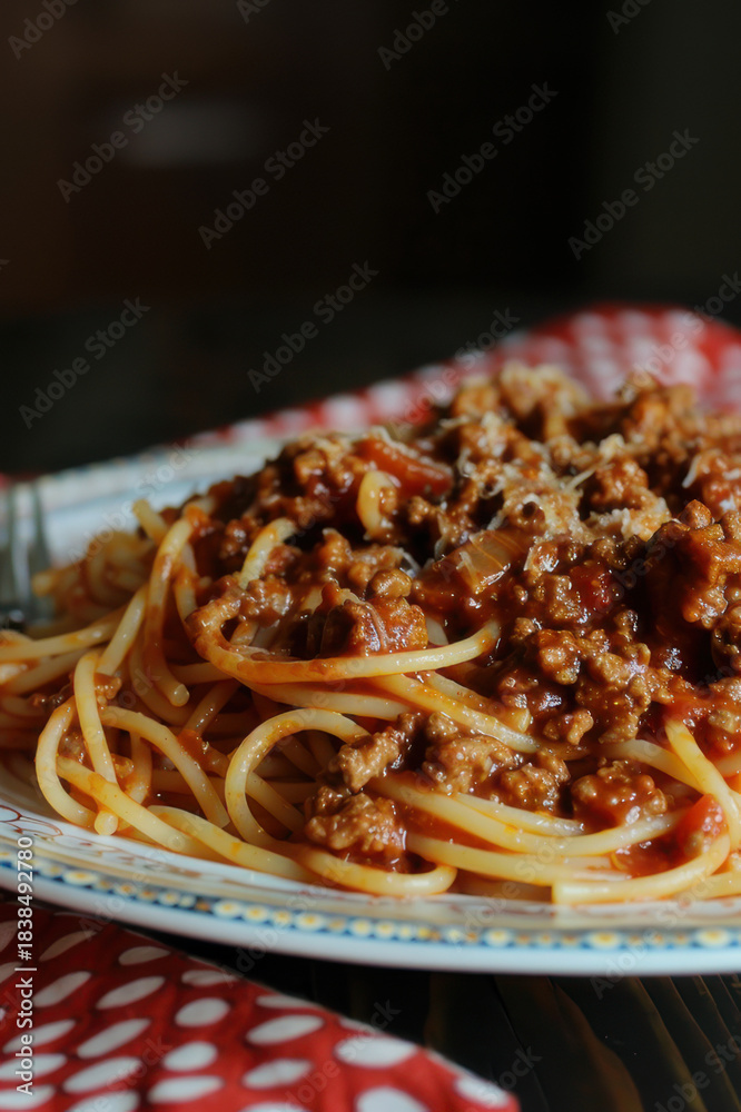 Fototapeta premium A close-up shot of delicious spaghetti Bolognese with rich meat sauce and grated cheese, perfect for Italian cuisine lovers.