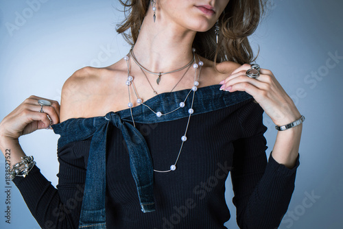 Young girl trying on a knitted sweater against a blue wall