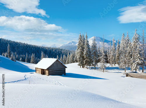 Winter calm mountain landscape with shed and mount ridge behind (Kukol Mount, Carpathian Mountains, Ukraine)