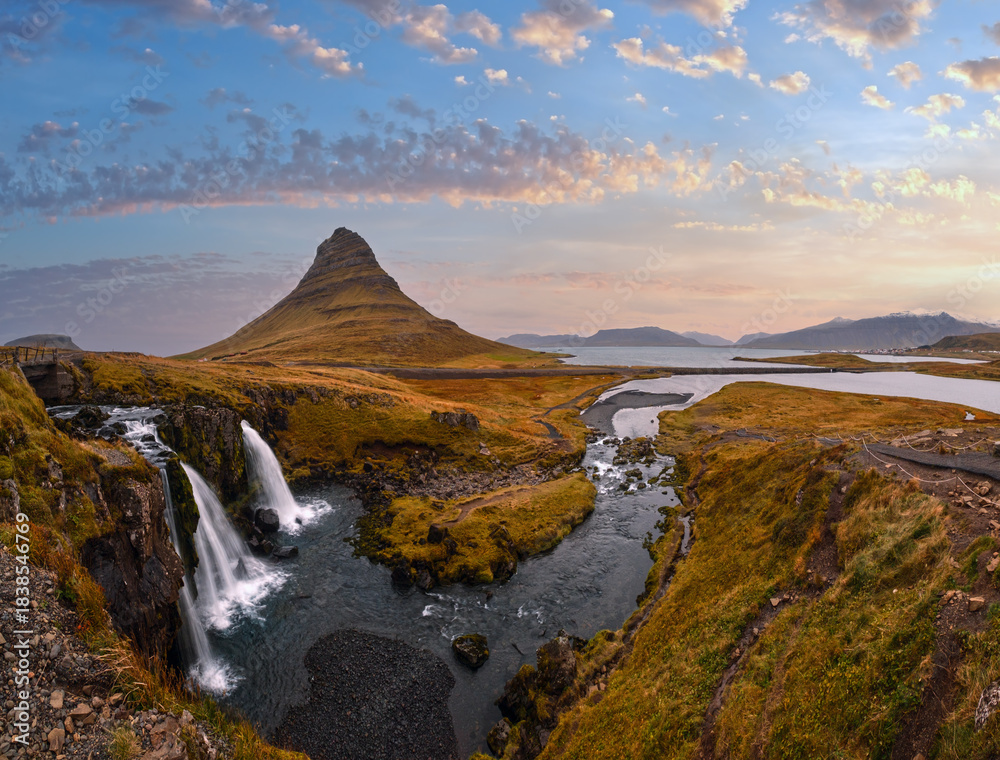 Obraz premium Famous picturesque Kirkjufell mountain and Kirkjufellsfoss waterfall next to Grundarfjörður at West Iceland autumn view.