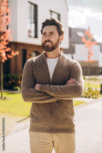 Fotografija Confident handsome Latin man with beard standing in suburban neighborhood lookin