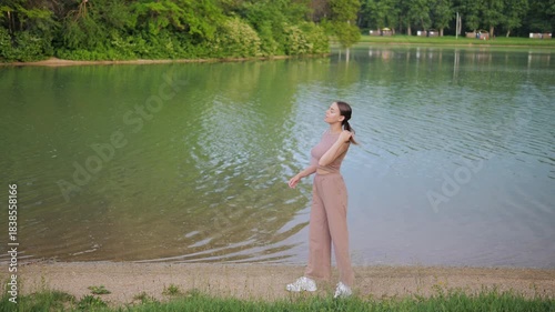 young woman poses in summer against backdrop of city lake