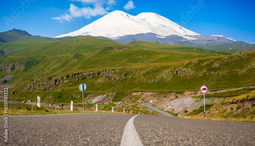 Canvas Print Road leading to Mount Elbrus with snow-covered peak and blue sky