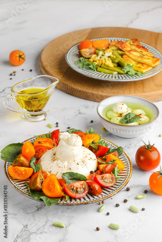 Foto Gourmet Burrata Cheese Salad with Heirloom Tomatoes and Fresh Basil