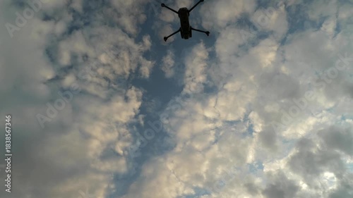 Drone flies straight across sky entering top center and moving away