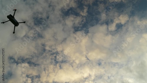 Drone enters frame from top left against blue sky