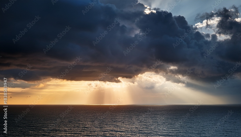 Obraz premium Sunlight Breaking Through Dark Storm Clouds With Dramatic Rays Over Ocean Horizon