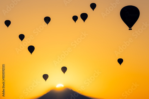 朝日に包まれるカッパドキアのシルエットの熱気球群