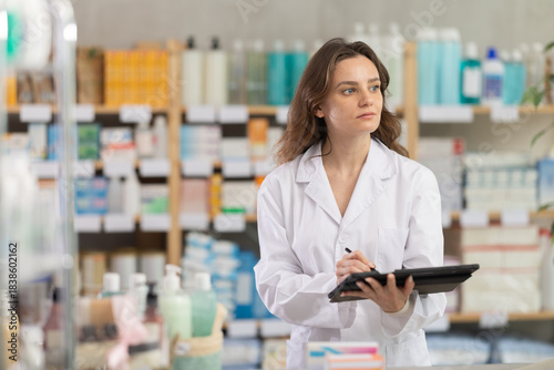 Adult woman pharmacist conducting inventory with tablet in pharmacy Free Download Adult woman pharmacist conducting inventory with tablet in pharmacy - GFXLoad