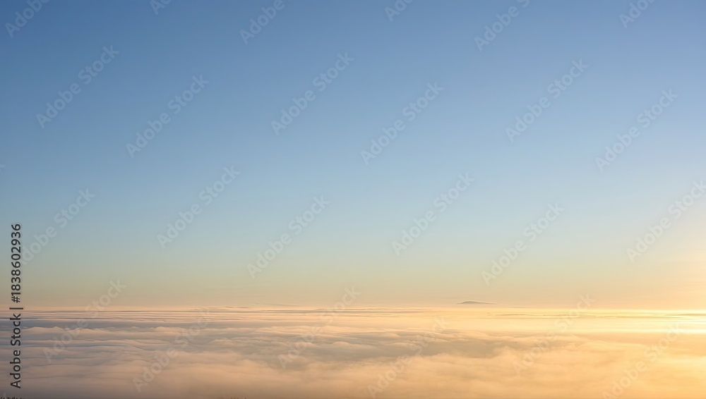 Fototapeta premium Aerial view above clouds at sunrise with blue sky and golden horizon, peaceful cloudscape from airplane window perspective